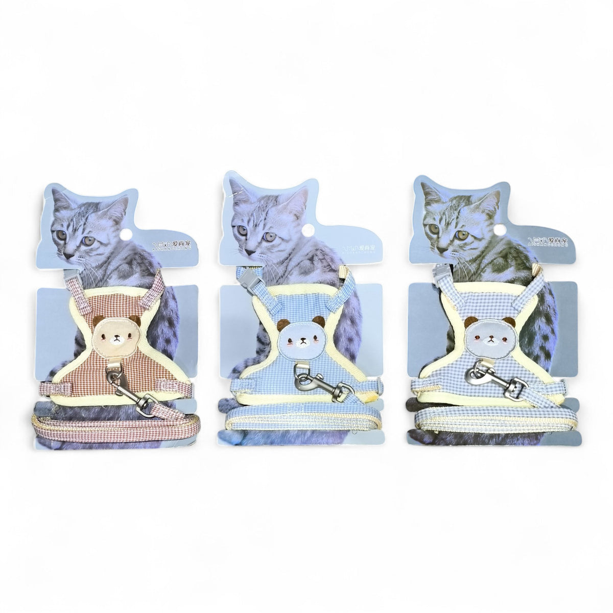 Three dog harnesses with teddy bear designs in pink, blue, and light blue gingham patterns, featuring adjustable straps and leash clips. Maroc-Animalerie.
